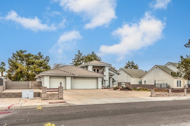 view of front of home with driveway, stucco siding, a garage, a fenced front yard, and a tiled roof