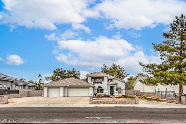 view of front of property featuring stucco siding, driveway, fence, an attached garage, and a tiled roof