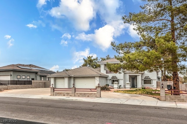 view of front of house with fence, stucco siding, concrete driveway, a garage, and a tile roof