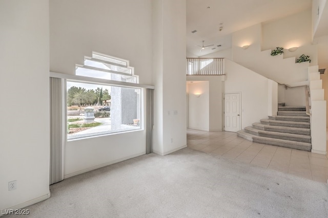3710 E Oquendo Rd, Las Vegas, NV 89120 - unfurnished living room with a high ceiling, carpet floors, stairs, and tile patterned floors