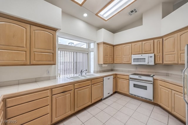 kitchen with white appliances, light tile patterned floors, visible vents, light brown cabinetry, and a sink