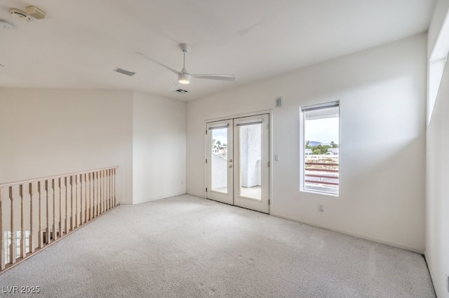 empty room featuring french doors, carpet floors, visible vents, and ceiling fan