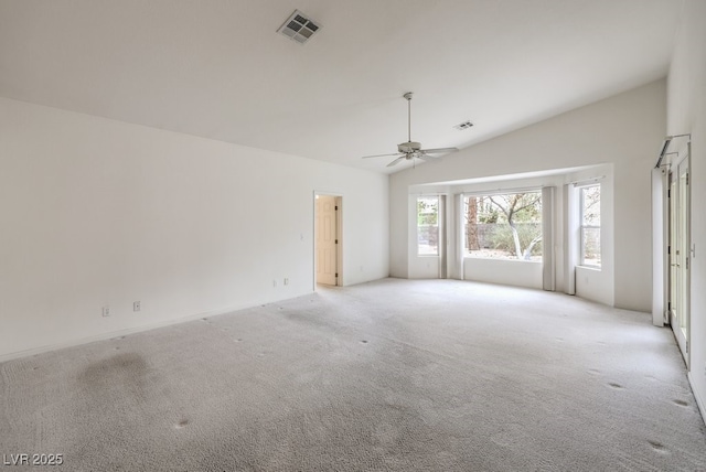 spare room with visible vents, lofted ceiling, light colored carpet, and ceiling fan