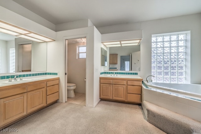 3710 E Oquendo Rd, Las Vegas, NV 89120 - bathroom featuring two vanities, carpet floors, a bath, and toilet