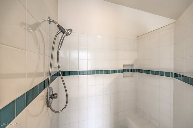 interior details featuring a tile shower