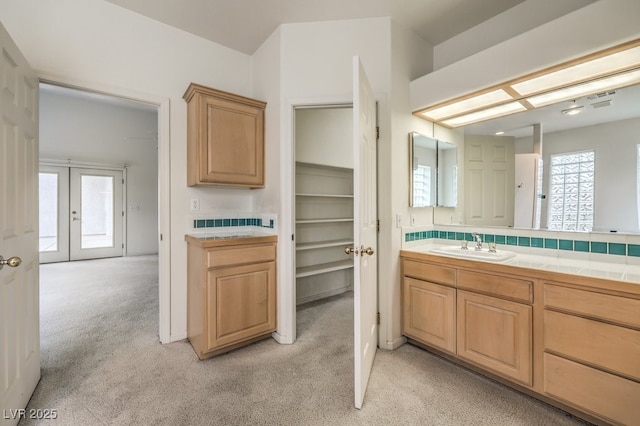 bathroom featuring vanity, carpet, and french doors