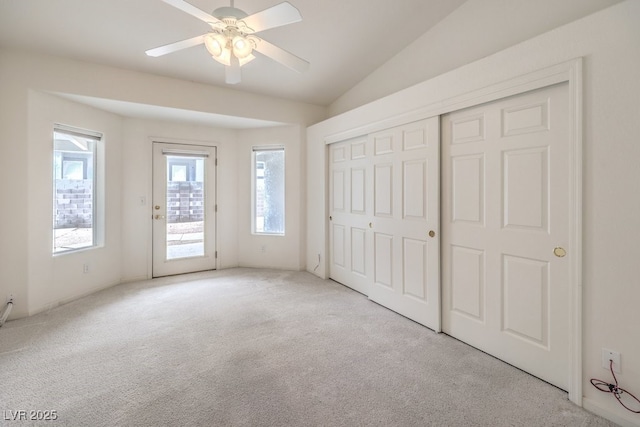 unfurnished bedroom featuring access to exterior, ceiling fan, carpet floors, vaulted ceiling, and a closet