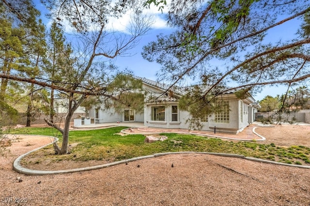 back of property with stucco siding, a tile roof, and a patio