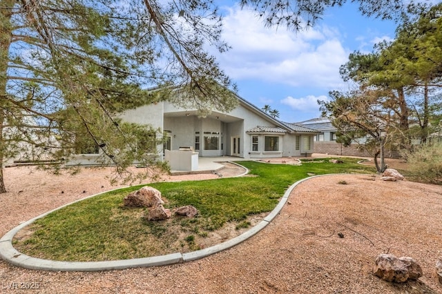 rear view of property with a patio area, stucco siding, and a lawn