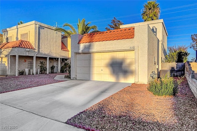 view of side of home with stucco siding, fence, concrete driveway, and a tiled roof