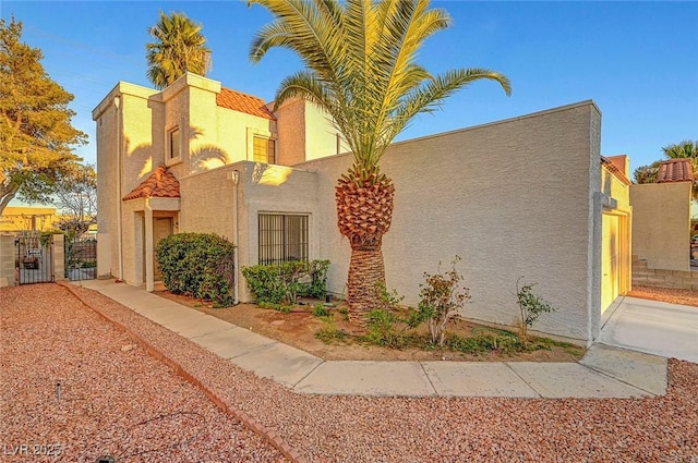 view of property exterior featuring stucco siding and a gate