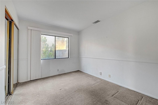 spare room featuring carpet flooring, baseboards, and visible vents