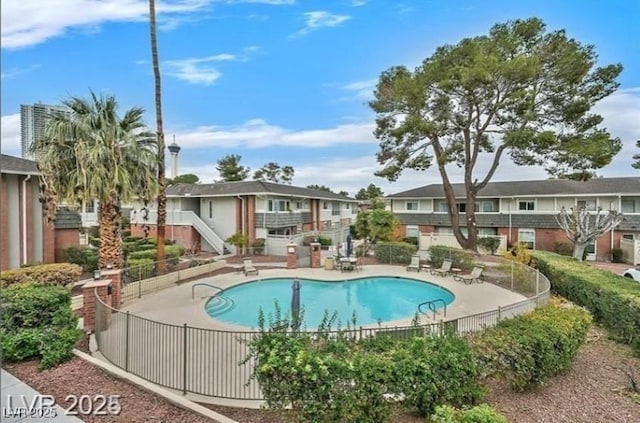 pool featuring a patio, fence, and a residential view