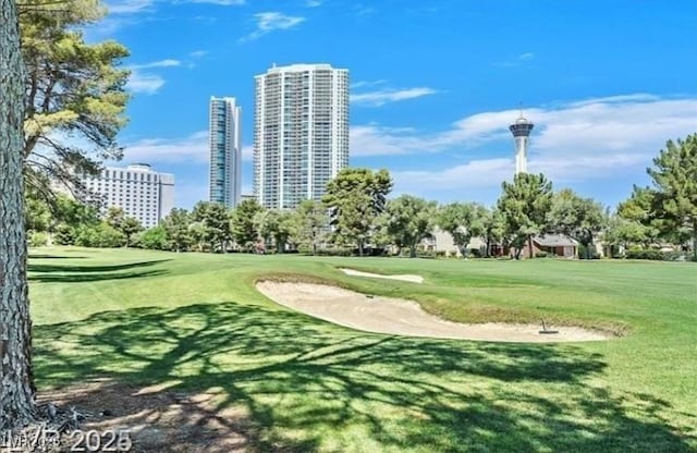 view of home's community featuring a view of city, a lawn, and golf course view