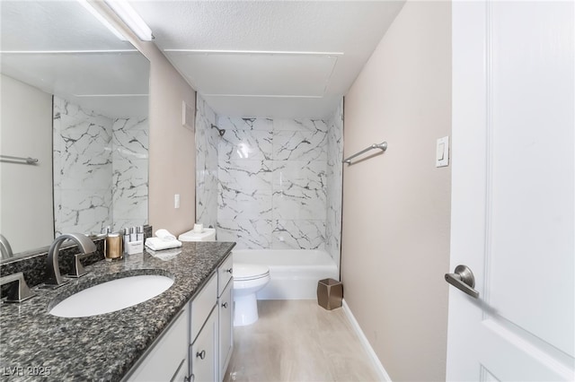 bathroom with vanity, toilet, bathtub / shower combination, and baseboards