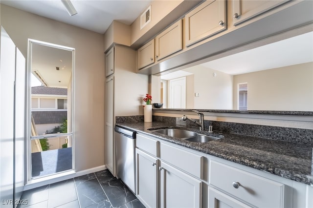 kitchen featuring visible vents, marble finish floor, a sink, dark stone countertops, and dishwasher