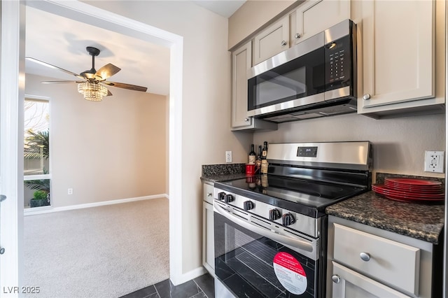 kitchen with a ceiling fan, baseboards, gray cabinets, appliances with stainless steel finishes, and dark carpet