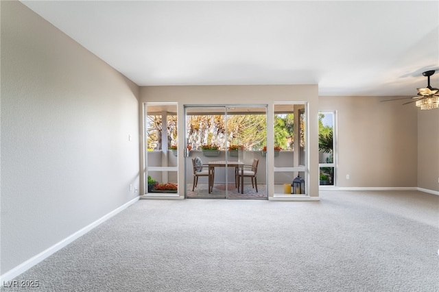 unfurnished living room with baseboards, ceiling fan, and carpet flooring