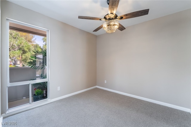 carpeted spare room featuring a ceiling fan and baseboards