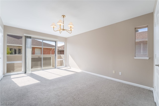 unfurnished room featuring baseboards, carpet floors, and a chandelier