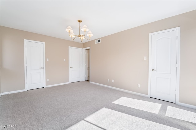 unfurnished bedroom with a chandelier, light colored carpet, and baseboards