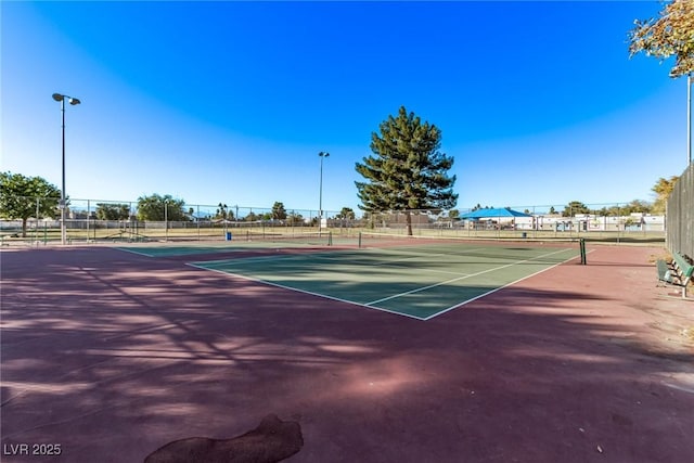 view of tennis court featuring fence