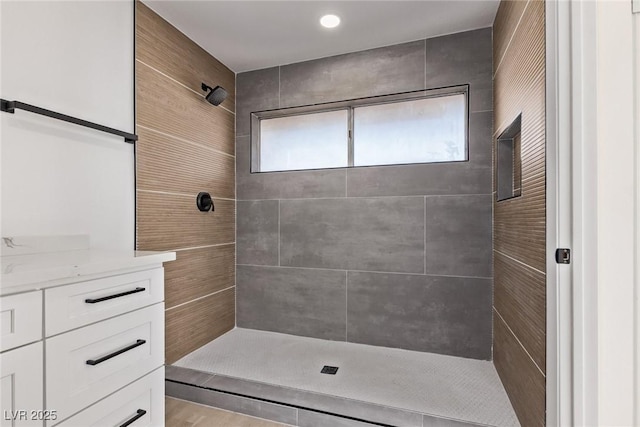 bathroom with vanity and a tile shower