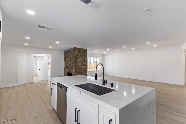 kitchen featuring a sink, visible vents, light wood-style floors, and stainless steel dishwasher