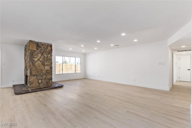 unfurnished living room with recessed lighting, baseboards, and light wood-style floors