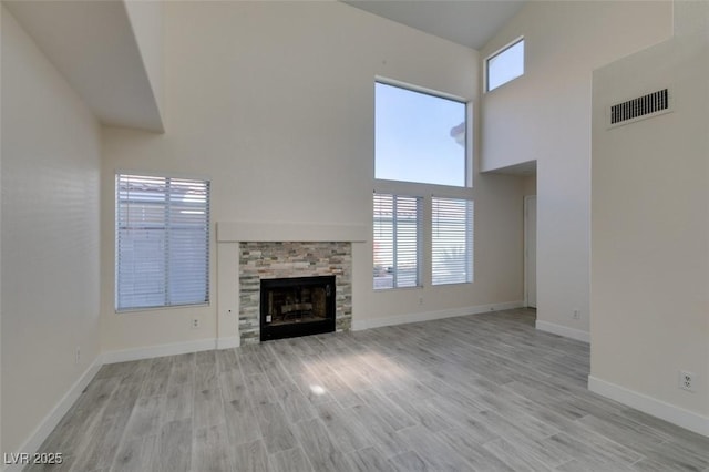 unfurnished living room with visible vents, plenty of natural light, and light wood-type flooring