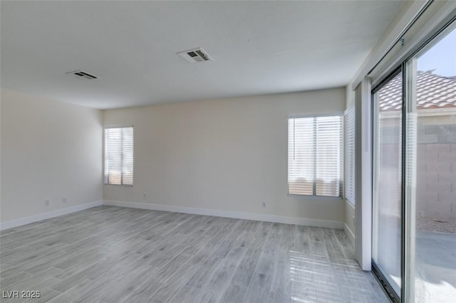 unfurnished room with visible vents, baseboards, and light wood-style floors