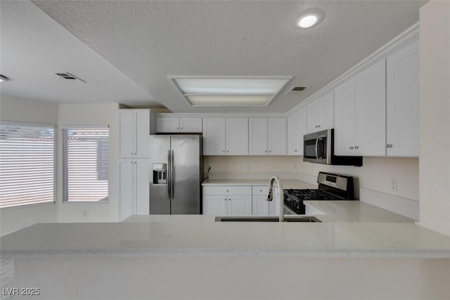 kitchen featuring a sink, white cabinets, visible vents, and stainless steel appliances