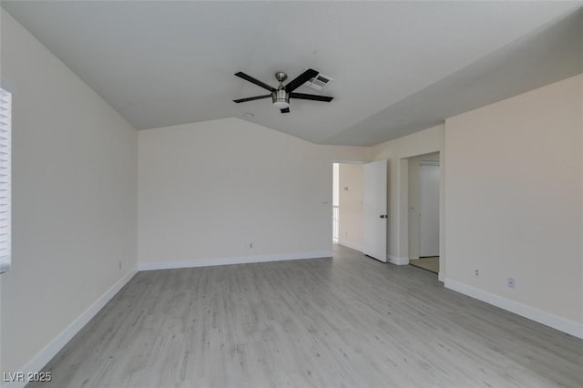 spare room featuring visible vents, light wood finished floors, baseboards, ceiling fan, and vaulted ceiling