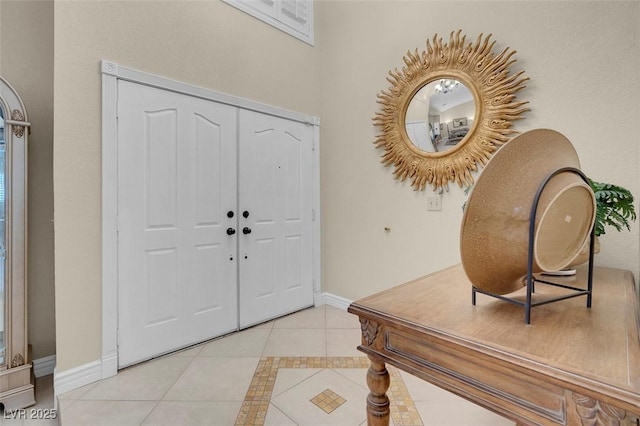 foyer with baseboards and light tile patterned floors