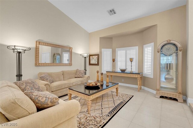 living room with vaulted ceiling, visible vents, baseboards, and light tile patterned floors
