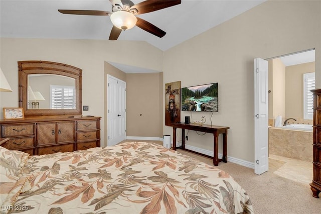 carpeted bedroom featuring multiple windows, ensuite bath, a ceiling fan, and vaulted ceiling