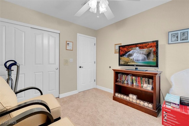 living area featuring ceiling fan, baseboards, and carpet flooring