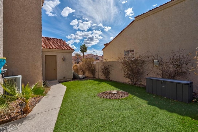 view of yard featuring central AC unit and fence