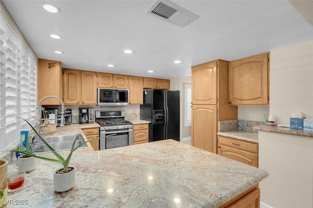 kitchen with visible vents, recessed lighting, appliances with stainless steel finishes, a peninsula, and a sink