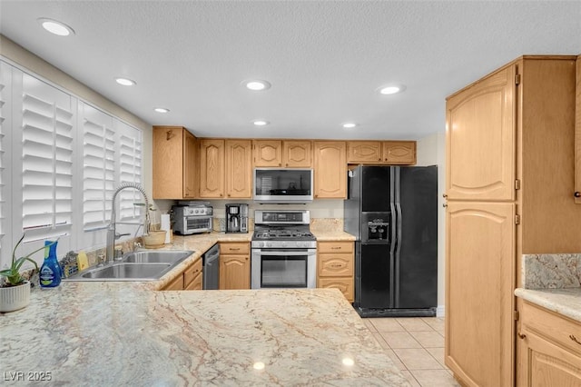 kitchen featuring light tile patterned floors, recessed lighting, appliances with stainless steel finishes, a textured ceiling, and a sink