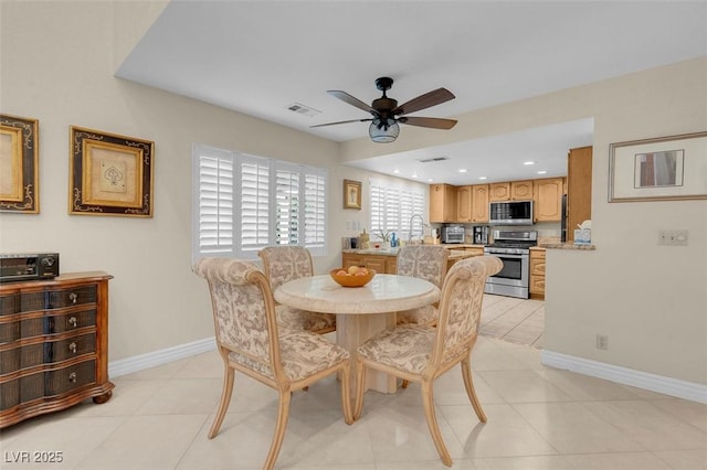 dining room featuring light tile patterned flooring, visible vents, baseboards, and ceiling fan