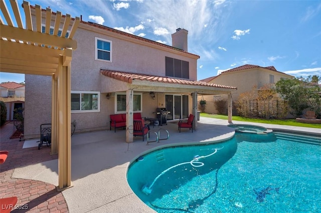 rear view of house with stucco siding, a pergola, and a patio area