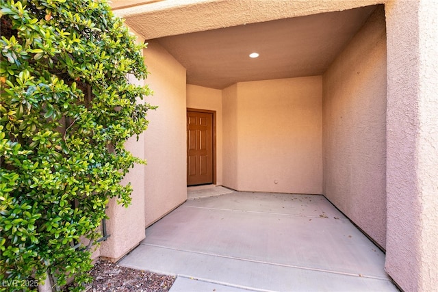 doorway to property featuring stucco siding