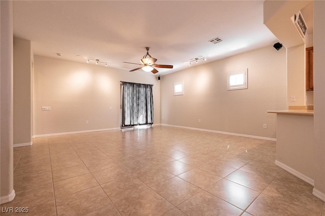 spare room featuring light tile patterned flooring, visible vents, rail lighting, and ceiling fan