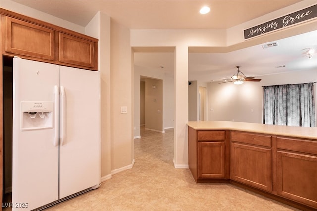 kitchen featuring visible vents, light countertops, brown cabinets, white fridge with ice dispenser, and a ceiling fan