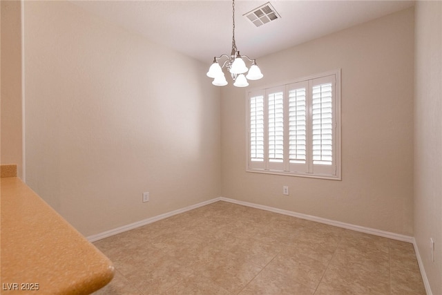 unfurnished room with visible vents, baseboards, and a chandelier