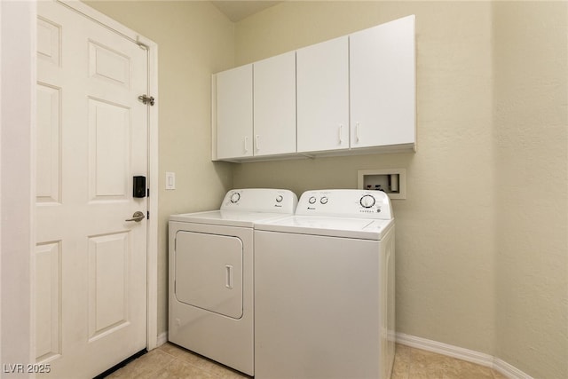 laundry area with washing machine and dryer, light tile patterned floors, cabinet space, and baseboards