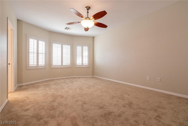 unfurnished room featuring light carpet, visible vents, baseboards, and a ceiling fan