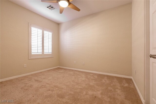 carpeted spare room featuring visible vents, baseboards, and a ceiling fan