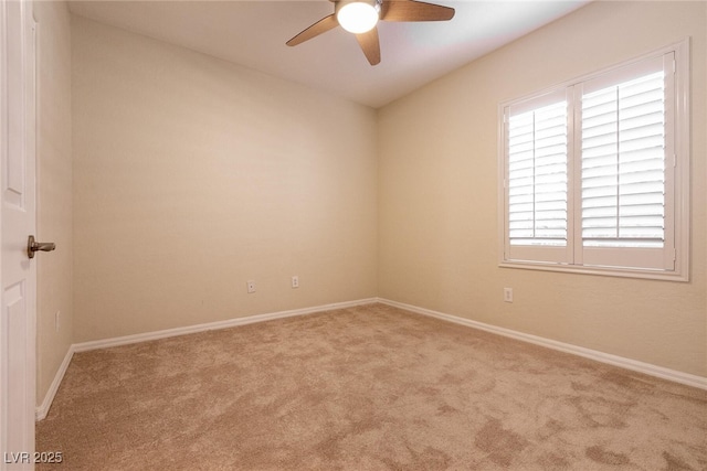 carpeted empty room featuring baseboards and ceiling fan